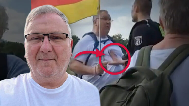 Das Bild zeigt Gerwin Dubnitzki, der von Polizisten wegen seiner Deutschlandfahne aufgehalten wurde.