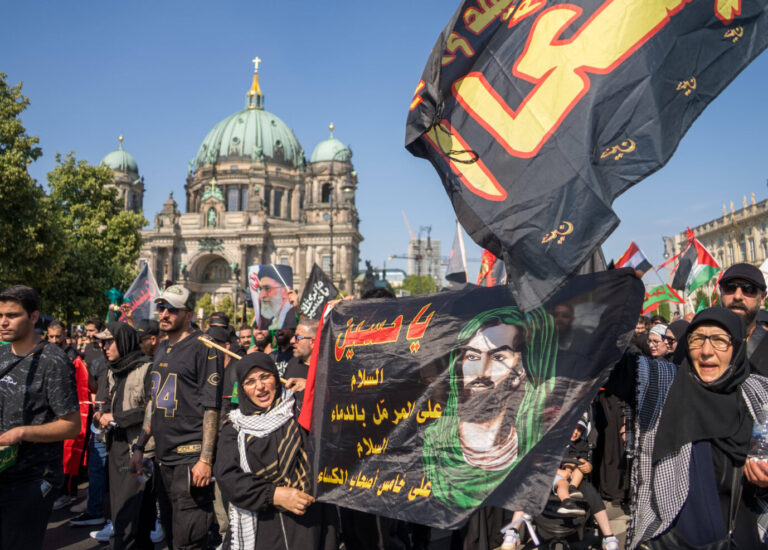 In Berlin schwenken Islamische Demonstranten eine Fahne und rufen den Namen des Hisbollah-Führers