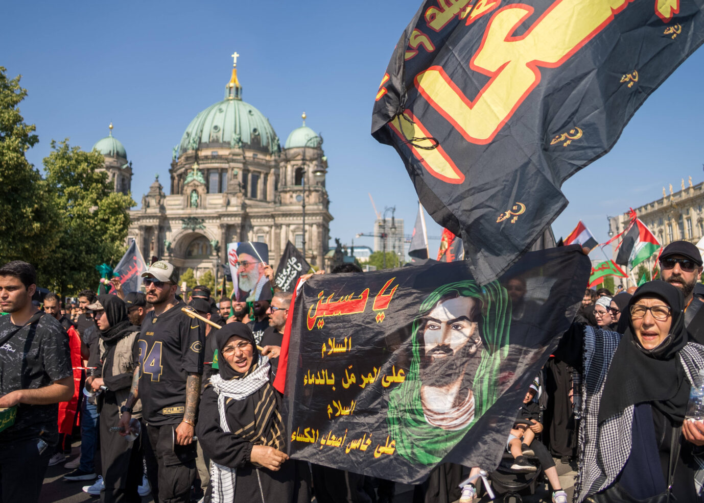 In Berlin schwenken Islamische Demonstranten eine Fahne und rufen den Namen des Hisbollah-Führers