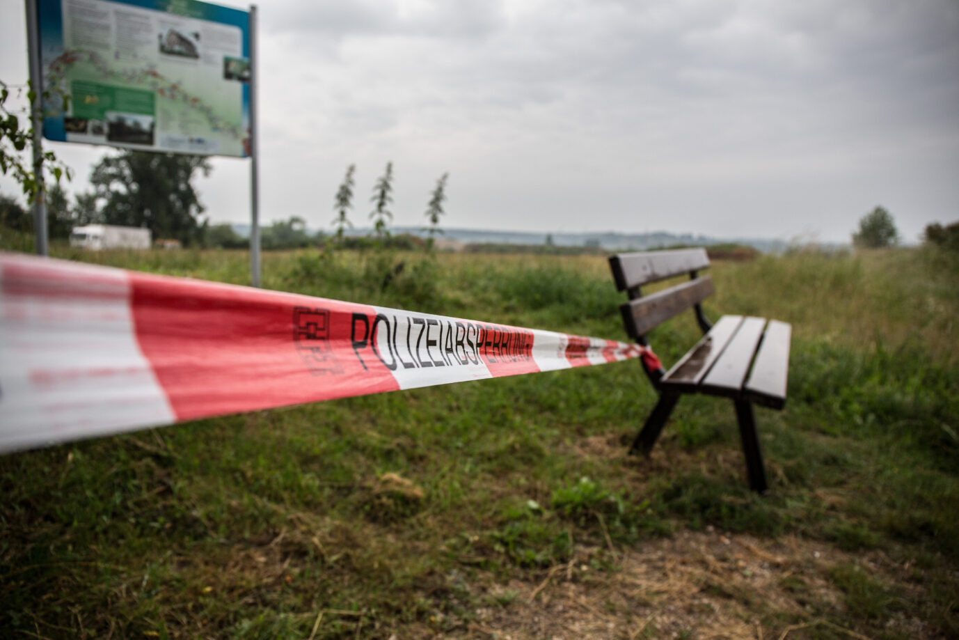 Eine Sitzbank in trister Landschaft, daneben flattert das Absperrband der Polizei: Symbolbild für die hohe Zahl an Gruppenvergewaltigungen