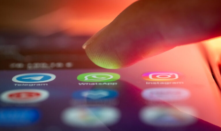 Finger über dem Smartphone, kurz vorm Öffnen einer Messenger-App. Künftig macht die Chatkontrolle eine Überwachung möglich.