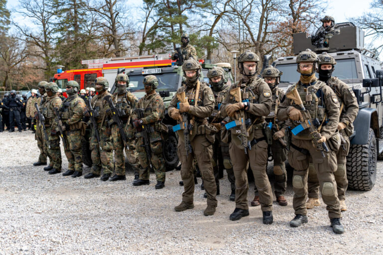 GETEX 2026: Gemeinsame Terrorabwehrübung von Bayerischer Polizei und Bundeswehr in Dachau. Es trainieren rund 300 Einsatzkräfte die Abwehr komplexer Sabotage- und Anschlagsszenarien in einem Dynamic Display. Feldjäger der Bundeswehr und Spezialeinsatzkräfte (SEK) der Polizei stehen gemeinsam vor gepanzerten Fahrzeugen und Einsatzfahrzeugen der Feuerwehr in geschlossener Formation bereit. Ihre Aufgabe ist es, den Staat zu beschützen.