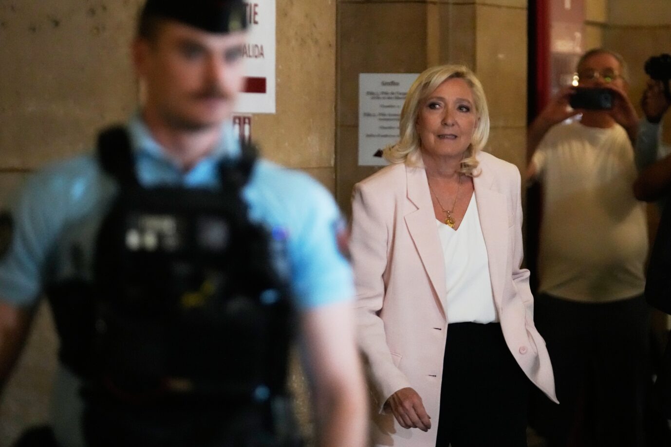 Marine Le Pen trägt einen pinken Blazer und wurde schuldig gesprochen