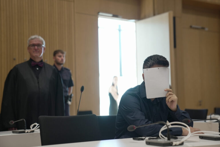 Der IS-Anhänger, Vergewaltiger, Jesidenversklaver und Angeklagte Twana H. hält sich im Gerichtssaal ein Blatt Papier vor das Gesicht