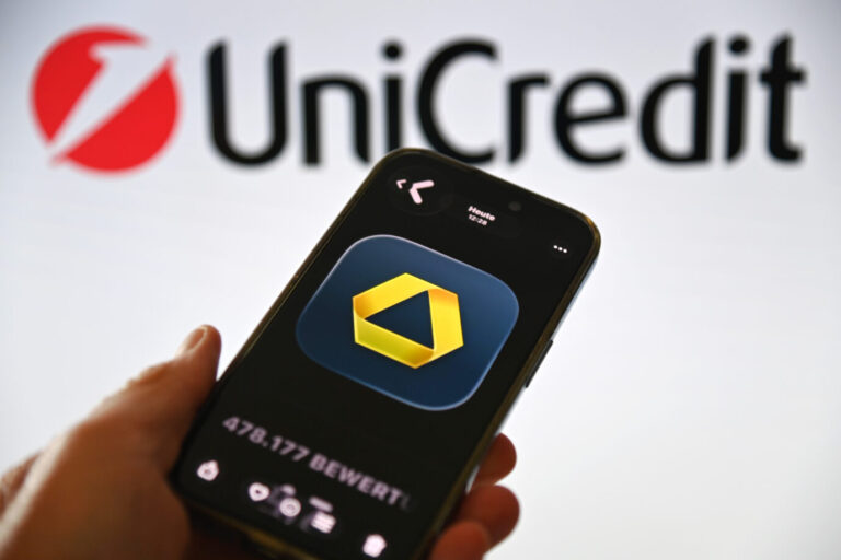 Durch das Übernahmevorhaben kontrolliert Unicredit jetzt fast 50 Prozent der zweitgrössten deutschen Privatbank. Commerzbank-App auf einem Smartphone vor dem UniCredit-Logo. Die Bank baut ihre digitale Präsenz und mobilen Finanzdienstleistungen weiter aus.
