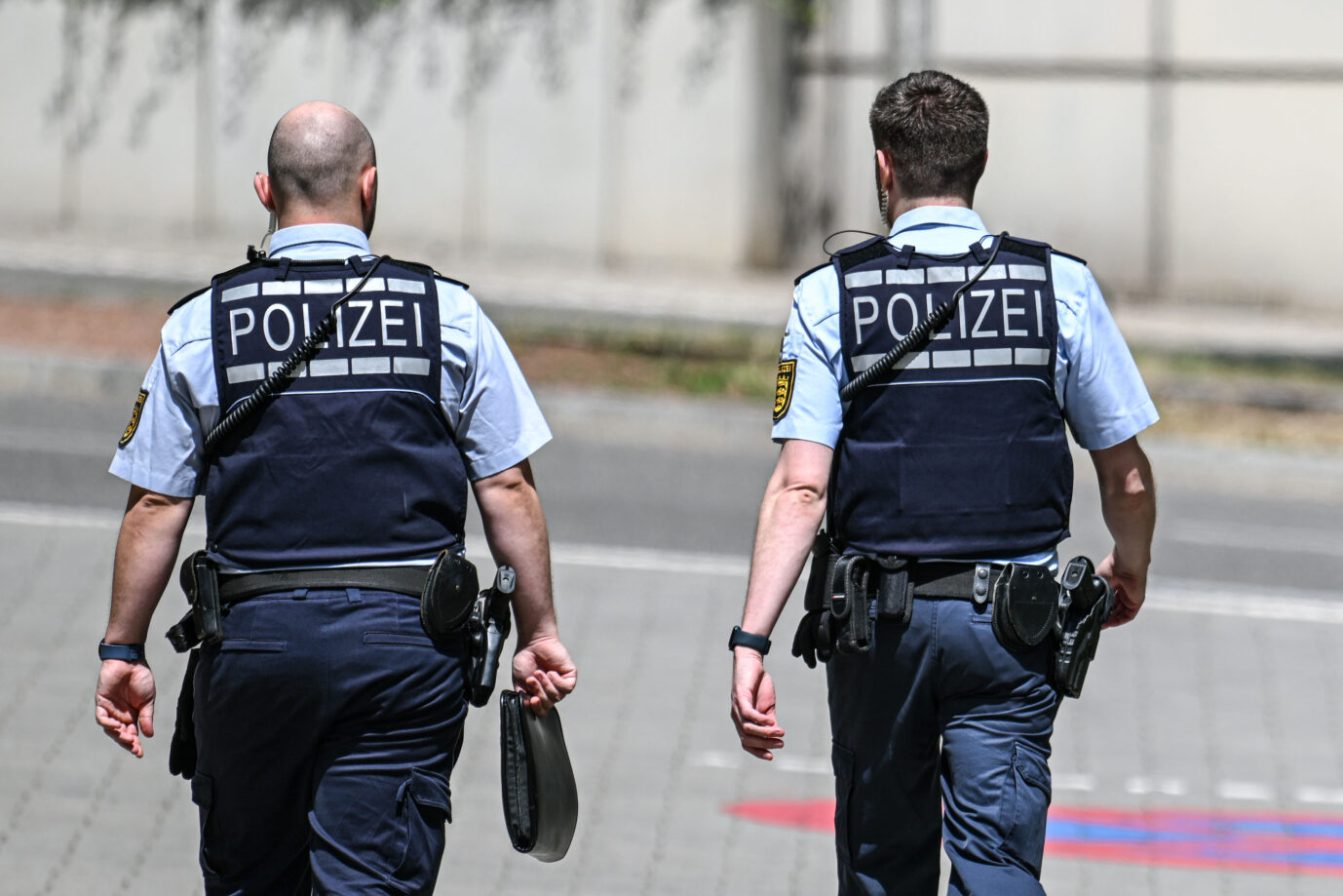 Zwei Personen in Polizeiuniform laufen über eine Straße – Symbolbild für den brutalen Mädchenangriff in Heidelberg