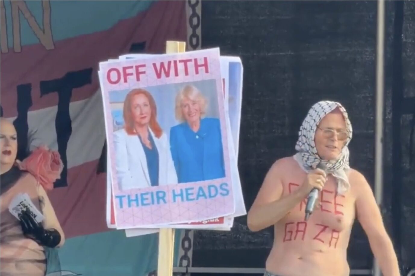 Eine halbnackte Transfrau spricht auf einer Bühne, davor hält jemand ein Plakat, das fordert, J.K. Rowling und Queen Camilla die Köpfe abzuhacken – Szenen des Londoner CSD