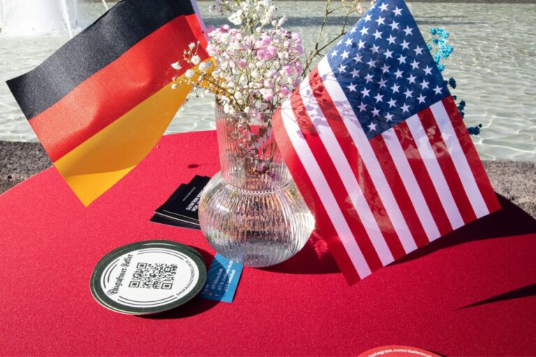 Das Bild zeigt eine Fahne von Deutschland und eine Fahne der USA.
