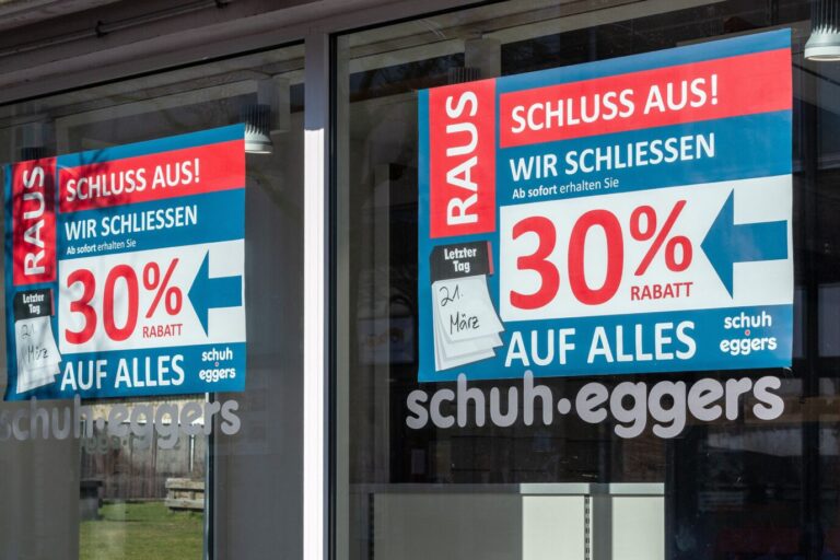 Schleswig, im Schaufenster des Schuhgeschaefts "Schuh Eggers" haengen Plakate mit der Aufschrift: "RAUS - SCHLUSS AUS! WIR SCHLIESSEN - Ab sofort erhalten Sie 30% RABATT AUF ALLES" Der letzte Tag dieses Einzelhandelsgeschaefts in der Schleswiger Fussgaengerzone war der 21. Maerz 2026. Damit schliesst ein weiteres Traditionsgeschaeft im Stadtweg. Es ist ein Symbolbild für einen journalisten Text über den Zustand der Wirtschaft in Deutschland.