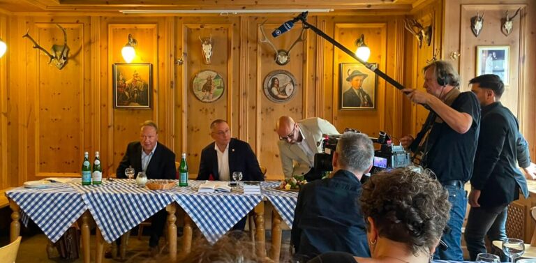 AfD-Chef Tino Chrupalla (m.) präsentiert seine Biographie in für viele Journalisten unerwarteter Umgebung.