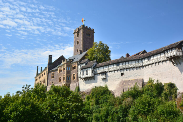 Das Bild zeigt die Wartburg, wo Martin Luther sich versteckt und das Neue Testament ins Deutsche übersetzt hat.