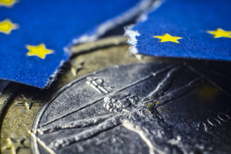 Italienische Euromünze und angerissene EU-Fahne, Symbolfoto Schuldenkrise in Italien