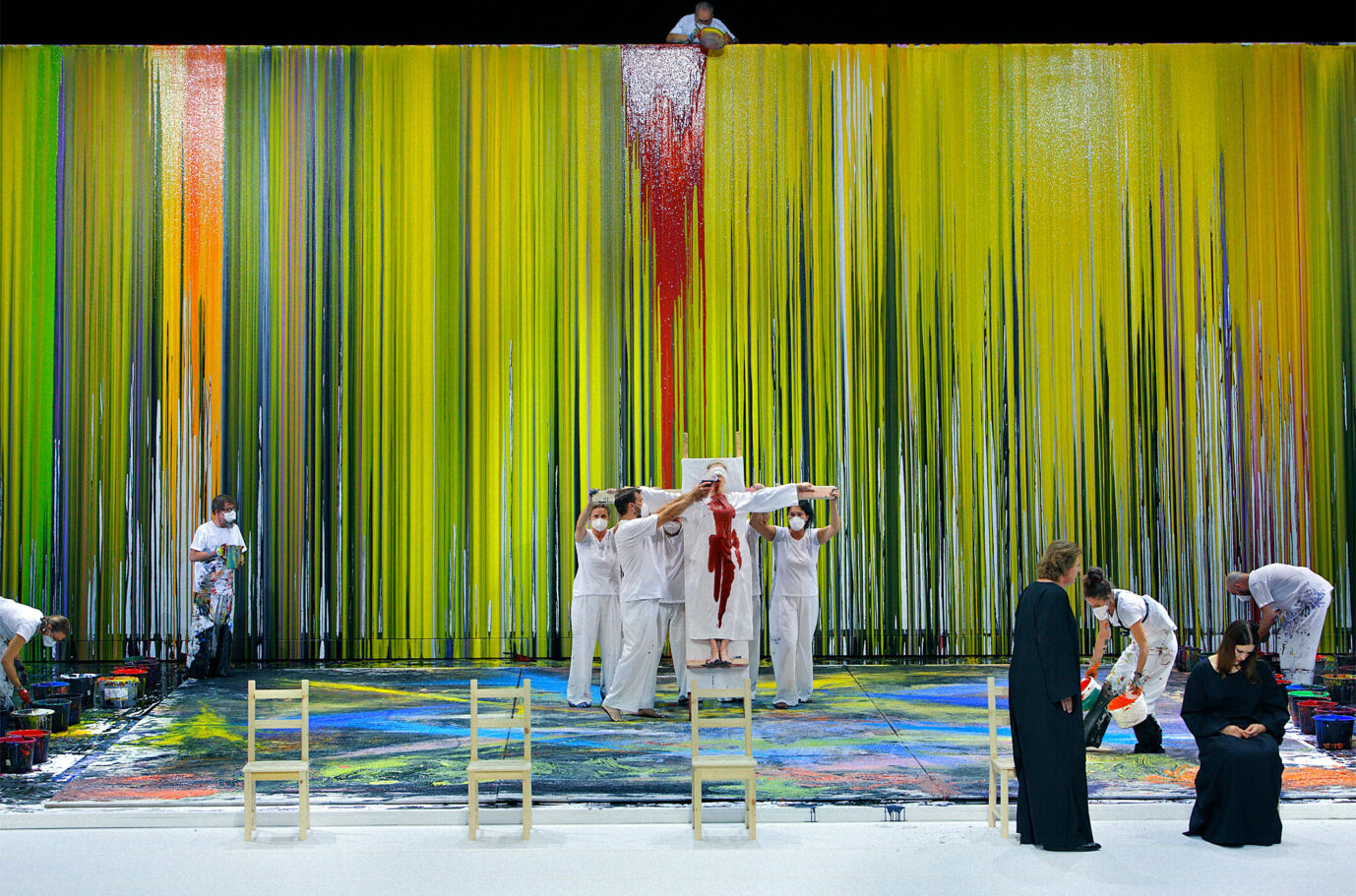 HANDOUT - Fotoprobe "Die Walküre": Klaus Florian Vogt (Siegmund, vorne l) und Irene Theorin (Brünnhilde, vorne r) stehen auf der Bühne, während im Hintergrund Malassistenten des österreichischen Aktionskünstlers Hermann Nitsch Farbe verschütten. Das Bühnenbild der "Walküre" wurde in diesem Jahr von "Blutkünstler" Nitsch gestaltet. Die Wagner-Oper feiert am 29.07.2021 Premiere bei den Bayreuther Festspielen 2021. Fotoprobe für die Aufführung „Die Walküre“ 2021: Das Stück sorgte für deutliche Buhrufe. Foto: picture alliance/dpa/Festspiele Bayreuth | Enrico Nawrath