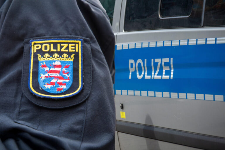 Symbolbild Polizeieinsatz in Hessen: Polizist der hessischen Polizei vor einem Einsatzfahrzeug (Composing). Polizeieinsatz in Hessen (Symbolbild): Der Türke soll einer Polizeibeamtin ein Büschel Haare ausgerissen haben. Foto: picture alliance / CHROMORANGE | Udo Herrmann. Ein 33jähriger Mann hat in einem Krankenhaus gewütet und einen Polizeieinsatz ausgelöst, an dessen Ende fünf Verletzte standen.