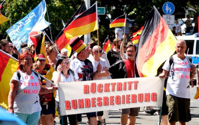 Teilnehmer der Demonstration des "Projekt M1llion" gehen durch die Stadt mit einem Transparent mit der Aufschrift "Rücktritt Bundesregierung". Foto: picture alliance/dpa | Sebastian Willnow