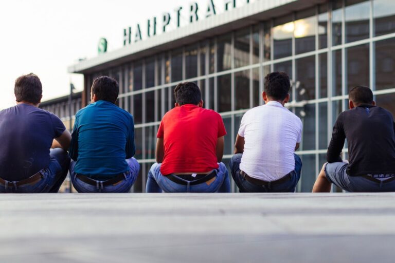 Migranten sitzen auf der Bahnhofstreppe am Kölner Hauptbahnhof. Köln, 24.07.2018