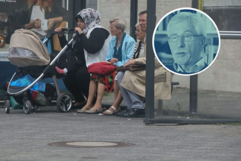 Muslima mit Kinderwagen und Deutsche warten im Bushaltehäuschen auf den Bus. Das Kindergeld steht aktuell in der Kritik.