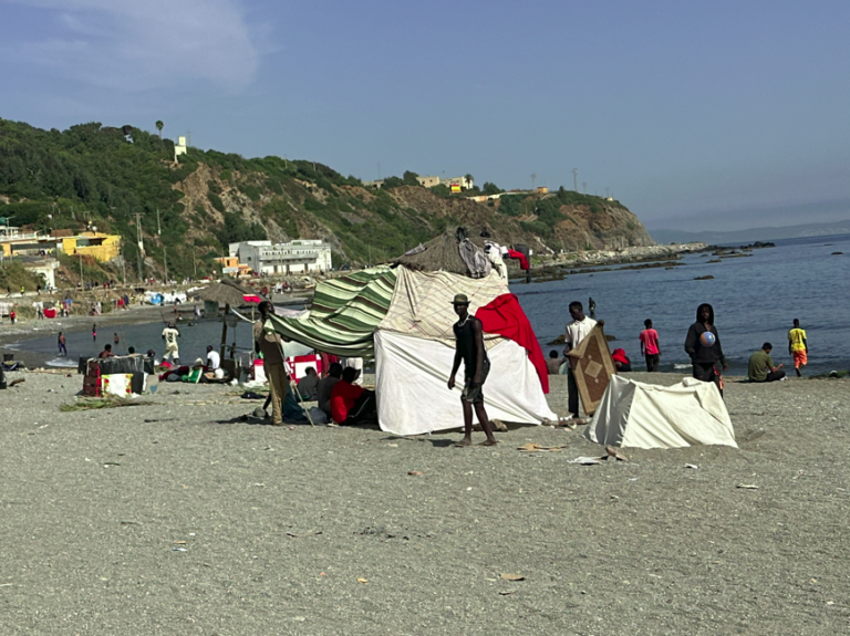 Migranten richten sich am Strand von Ceuta ein.