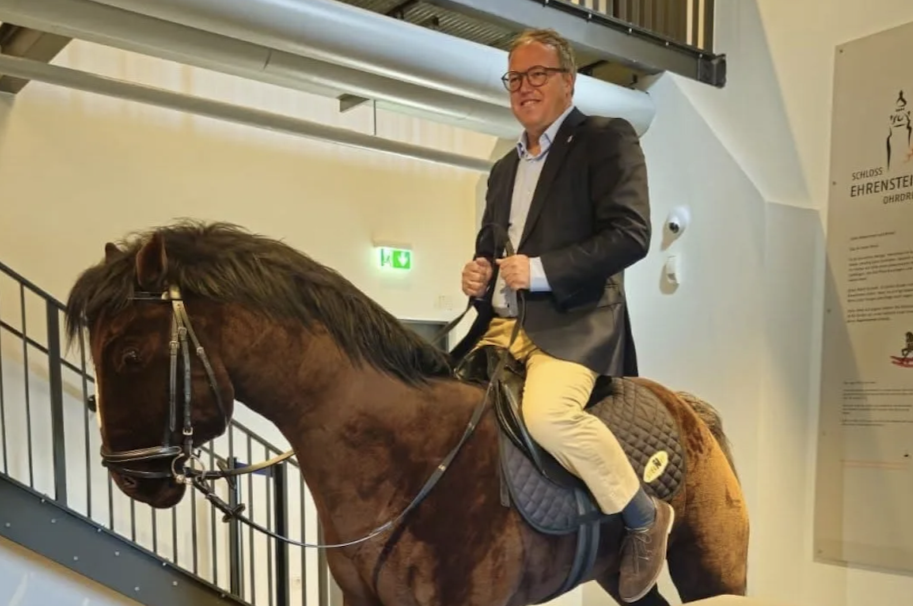 Hoch zu Ross, die Zügel fest in der Hand: Thüringens Ministerpräsident Mario Voigt (CDU) auf einem Schaukelpferd.