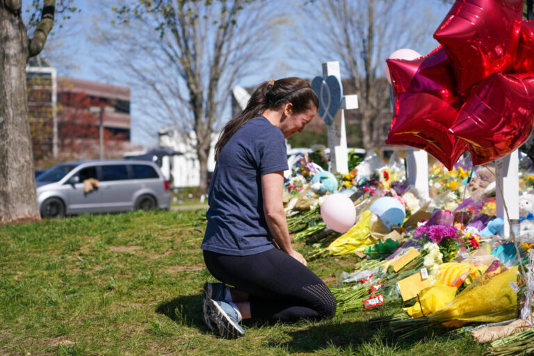 Eine Frau vor kniet einem Meer aus Blumen und Luftballons: Es handelt sich um eine Szene vom März 2023, nachdem eine Transperson an einer Schule sechs Menschen ermordet hatte