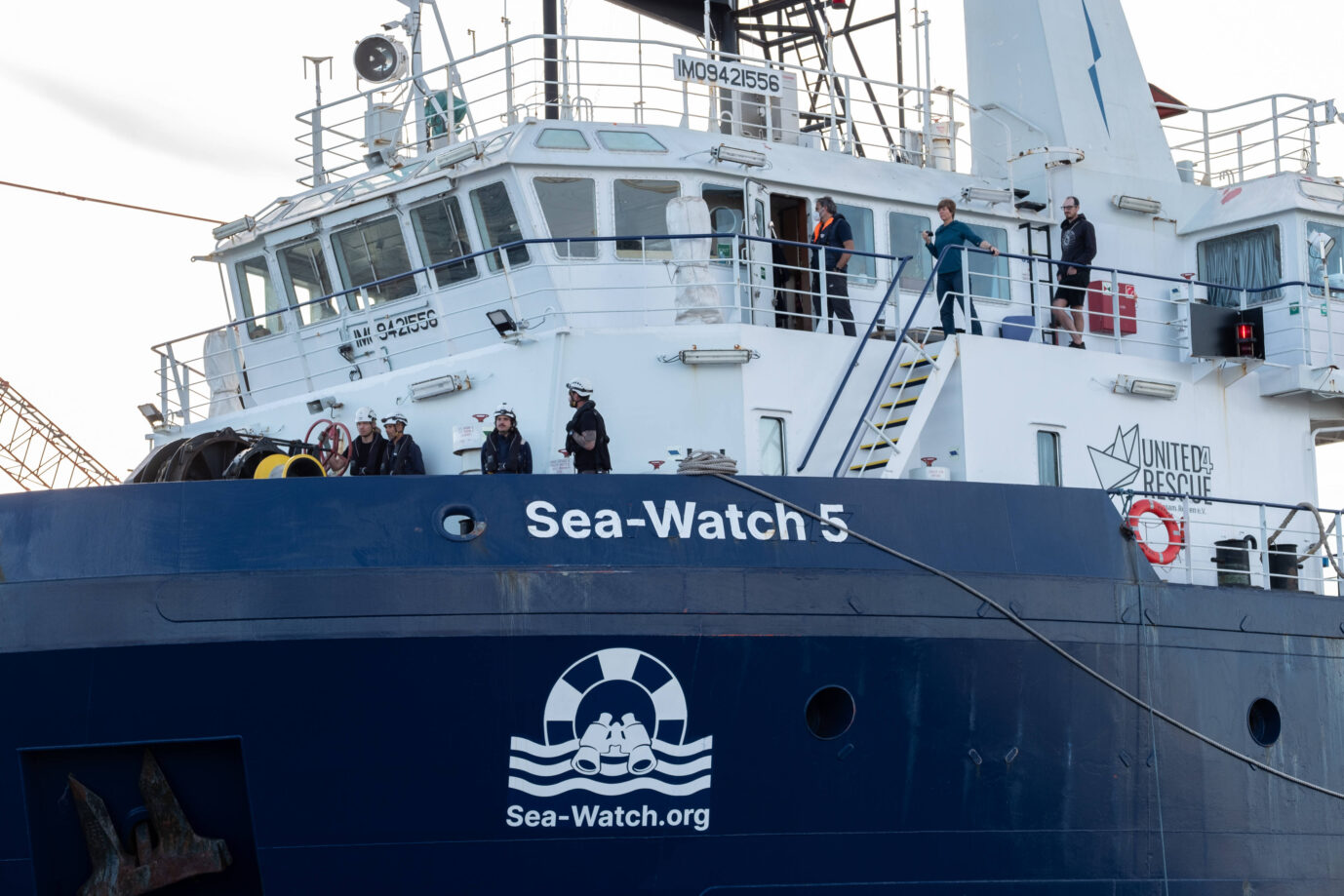 Man sieht Menschen auf der blau-weißen Sea-Watch 5 herumlaufen – und erstmal werden sie wohl im Hafen von Neapel bleiben müssen.