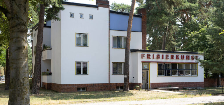Umgeben von Bäumen stehen in Berlin zwei Häuser im Bauhaus-Stil